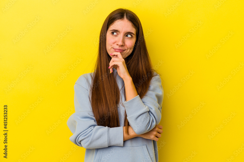 Young caucasian woman isolated on yellow background looking sideways with doubtful and skeptical expression. Young caucasian woman isolated on yellow background looking sideways with doubtful and skeptical expression.