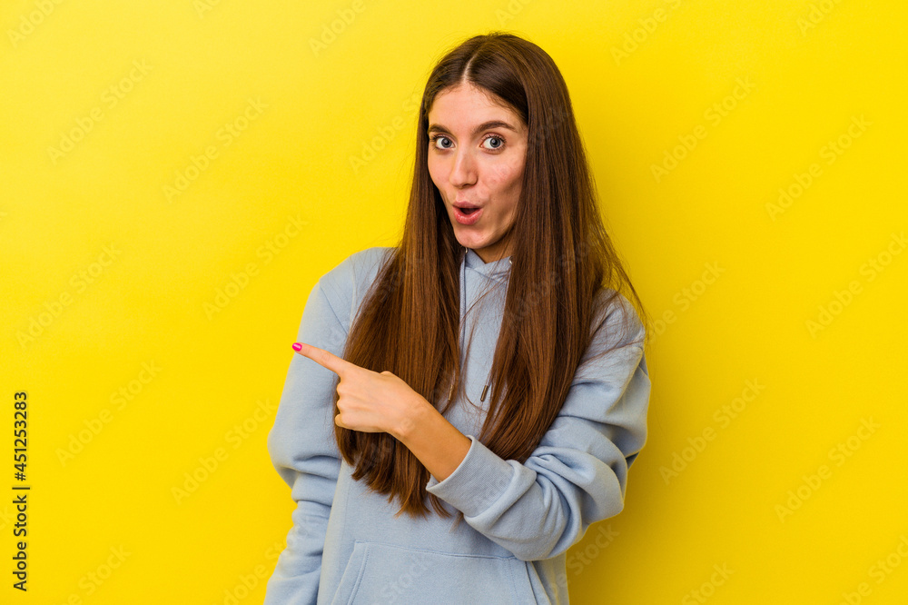 Young caucasian woman isolated on yellow background pointing to the side Young caucasian woman isolated on yellow background pointing to the side