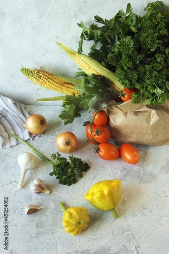  Fresh ripe variety of vegetables and greens in an ecological paper bag, on a light background, organic natural products, healthy food, home cooking