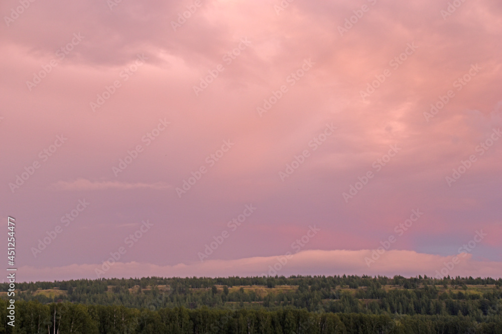 Sunset horizon with red clouds in the summer in the field