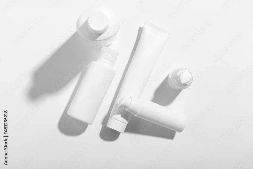 Fototapeta premium A set of cosmetic products in white tubes with empty space for labeling. Cosmetics for face and body skin care. Moisturizing cream, purifying mask.