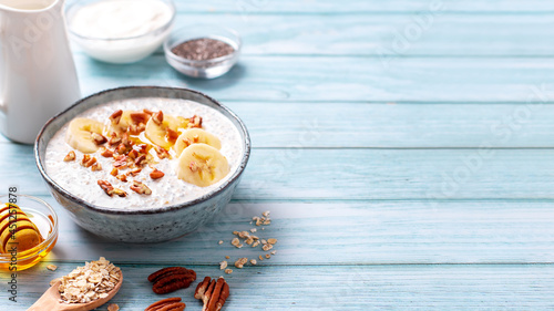 Banana and pecan nuts overnight oatmeal with chia seeds in bowl, rich in protein breakfast or snack photo