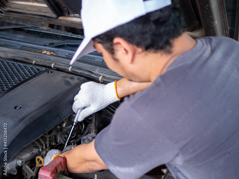 Mechanic holding a block wrench handle while fixing a car. Mechanic holding a block wrench handle while fixing a car.