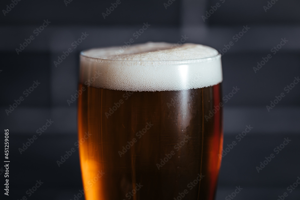 Close up of top of beer glass with foam