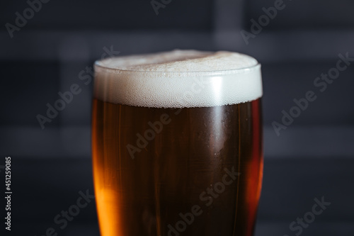 Close up of top of beer glass with foam