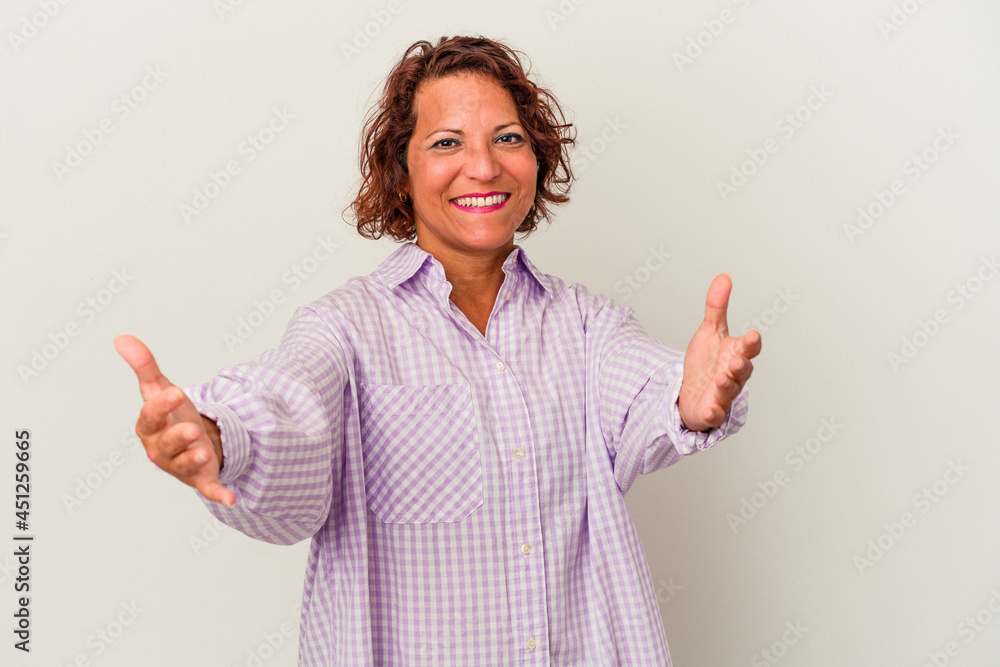 Middle age latin woman isolated on white background showing a welcome expression. Middle age latin woman isolated on white background showing a welcome expression.