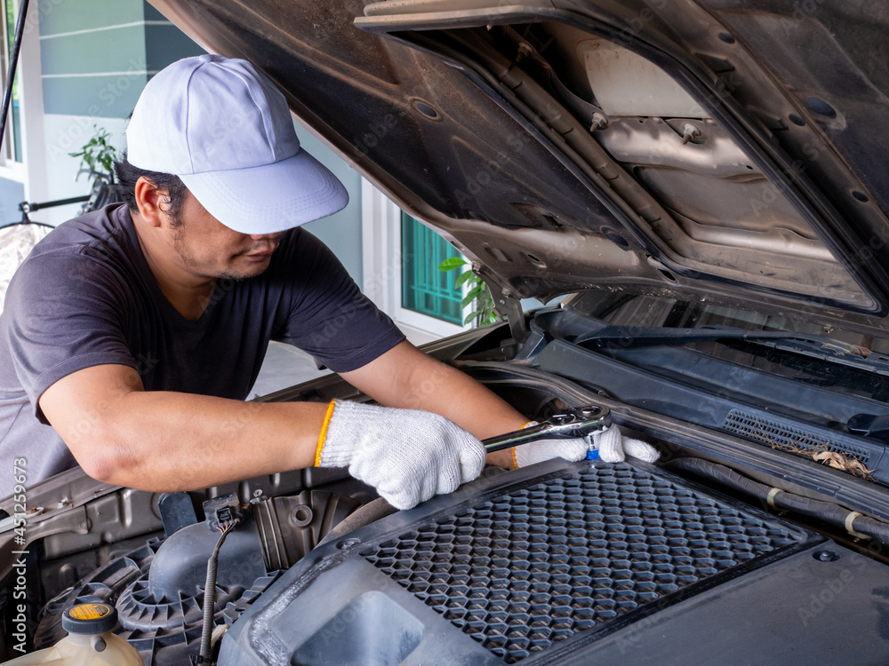 Mechanic holding a block wrench handle while fixing a car. Mechanic holding a block wrench handle while fixing a car.