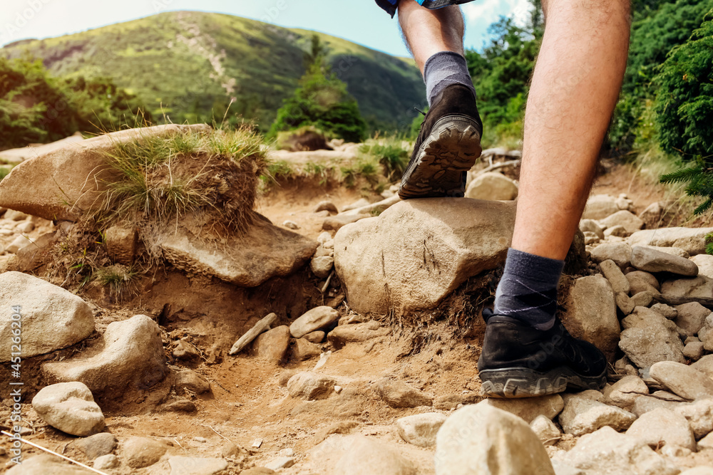 Hiking in Carpathian mountains. Close up of hiker's shoes. Man walking on rocks. Traveling in summer Ukraine Hiking in Carpathian mountains. Close up of hiker's shoes. Man walking on rocks. Traveling in summer Ukraine