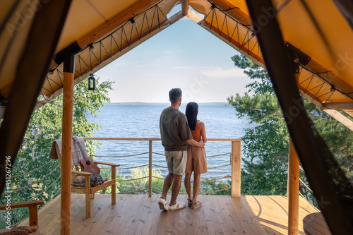 rear view of affectionate couple enjoying summer vacation in glamping house photo