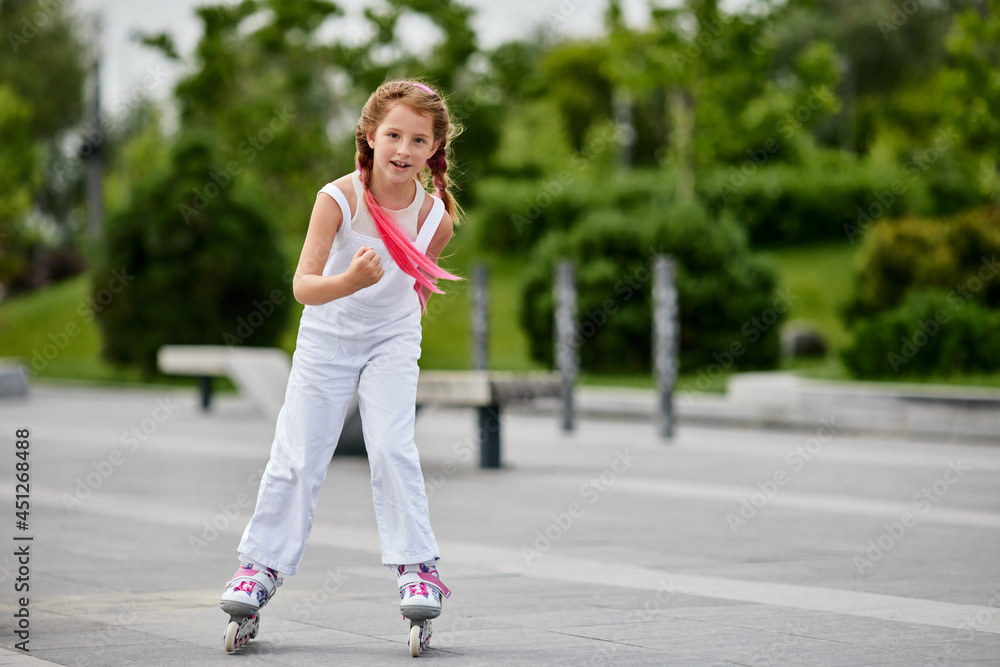 Cute little child girl on roller skates