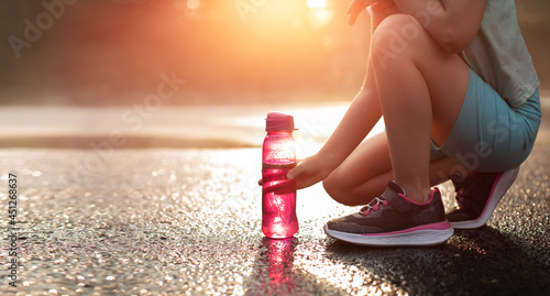 Drinking water concept. A young runner reaches for a bottle of water.