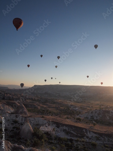 Various balloons flying in the sky, desert, land