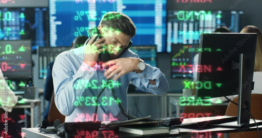 Close up of caucasian male broker working at computer in trading office and answering phone calls on many telephones. Trader buying and selling while talking with clients and working at stock market Close up of caucasian male broker working at computer in trading office and answering phone calls on many telephones. Trader buying and selling while talking with clients and working at stock market