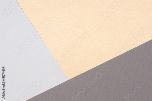 Creative abstract geometric paper background gray colors and brown craft paper. Top view. Copy space