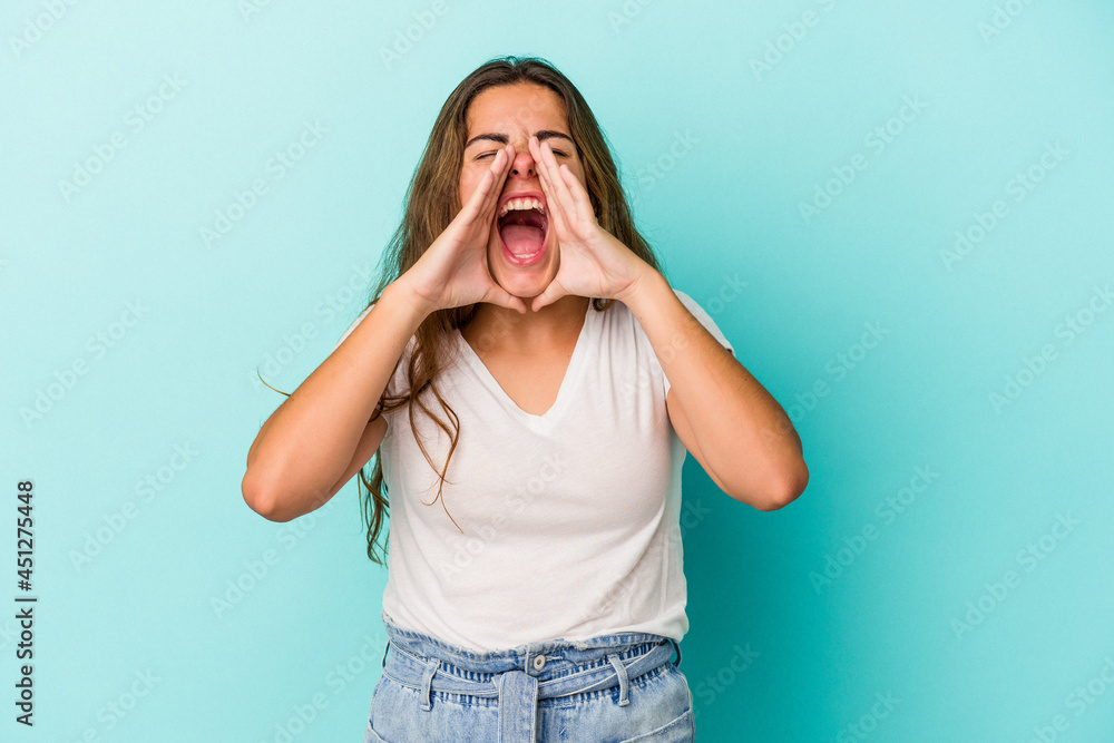 Young caucasian woman isolated on blue background  shouting excited to front.