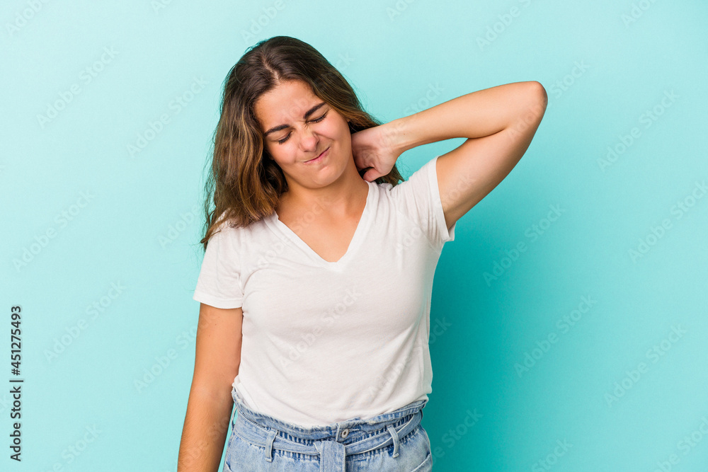 Young caucasian woman isolated on blue background suffering neck pain due to sedentary lifestyle. Young caucasian woman isolated on blue background suffering neck pain due to sedentary lifestyle.
