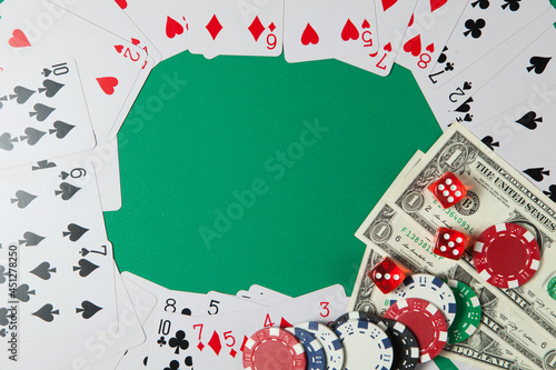 Classic playing cards, chips, red dice and dollars on green background. Gambling and casino concept.