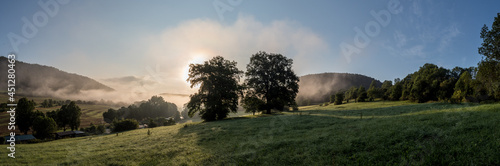 Thüringer  Mittelgebirge mit Sonne, Bäumen und Nebel am Morgen
