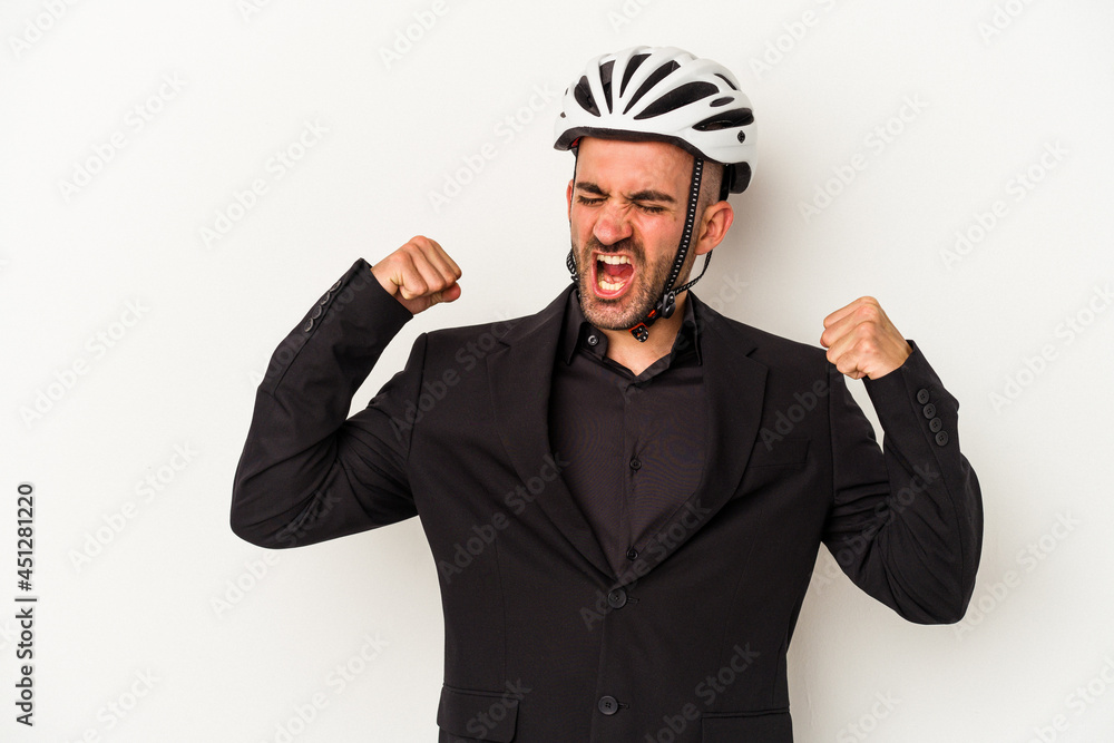 Young business bald man wearing a bike helmet isolated on white background raising fist after a victory, winner concept. Young business bald man wearing a bike helmet isolated on white background raising fist after a victory, winner concept.