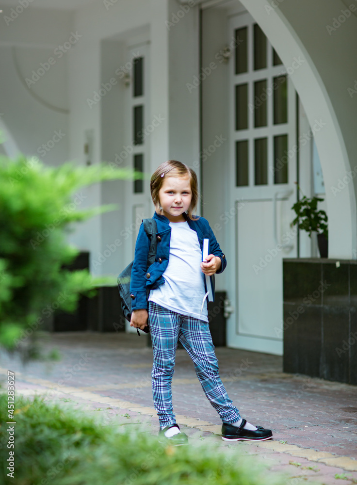 a beautiful little girl, a schoolgirl, in the afternoon near the school, in a school uniform a beautiful little girl, a schoolgirl, in the afternoon near the school, in a school uniform