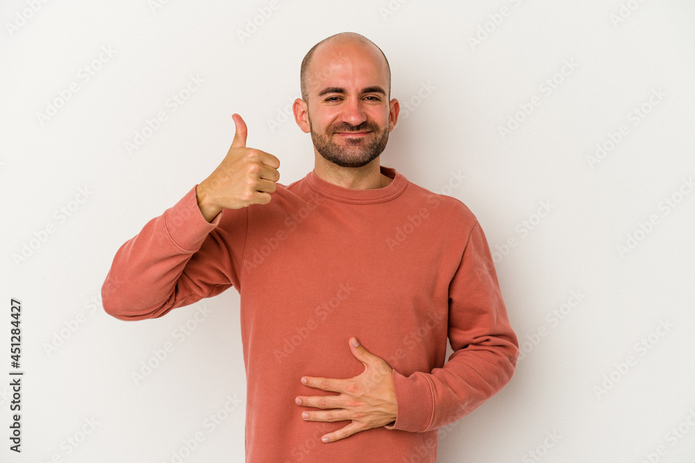 Young bald man isolated on white background touches tummy, smiles gently, eating and satisfaction concept. Young bald man isolated on white background touches tummy, smiles gently, eating and satisfaction concept.