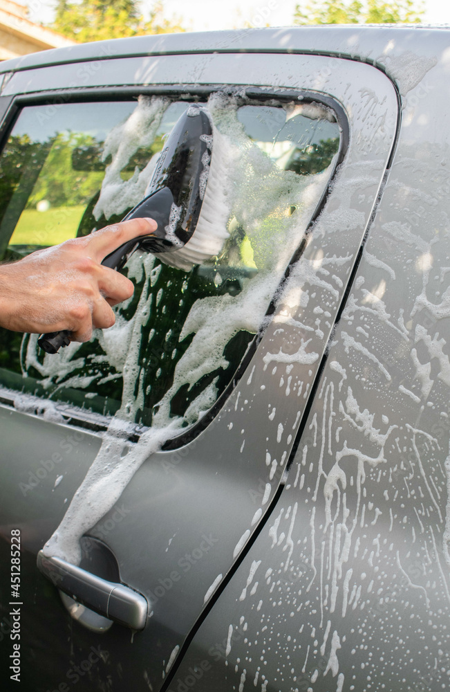 Man washing a car with a brush