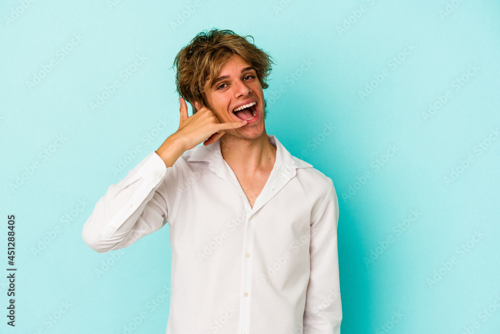 Young caucasian man with make up isolated on blue background showing a mobile phone call gesture with fingers. Young caucasian man with make up isolated on blue background showing a mobile phone call gesture with fingers.