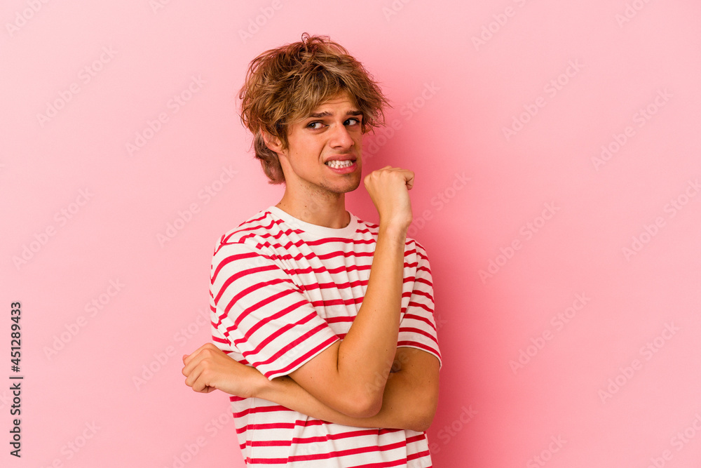 Young caucasian man with make up isolated on pink background confused, feels doubtful and unsure. Young caucasian man with make up isolated on pink background confused, feels doubtful and unsure.