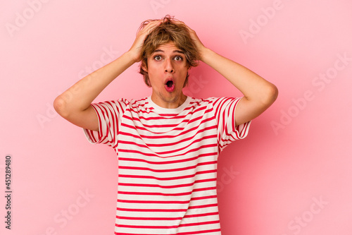 Young caucasian man with make up isolated on pink background surprised and shocked.