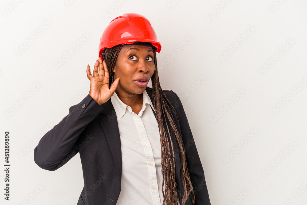 Young african american architect woman isolated on white background trying to listening a gossip. Young african american architect woman isolated on white background trying to listening a gossip.