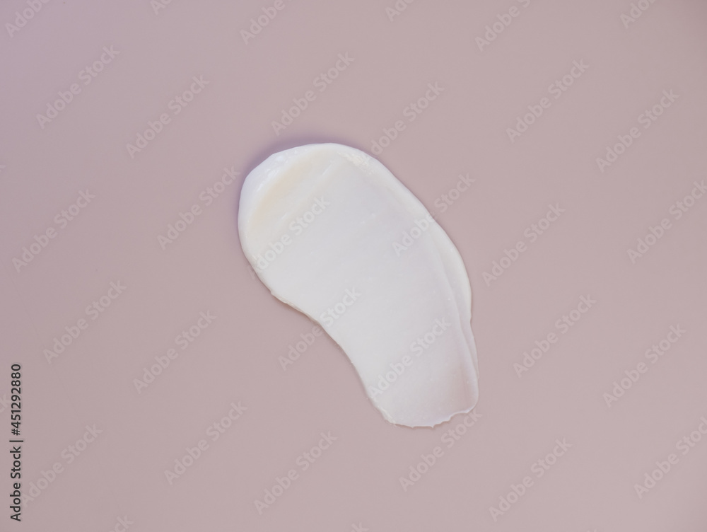White cream texture on a pink background. White cream texture on a pink background.