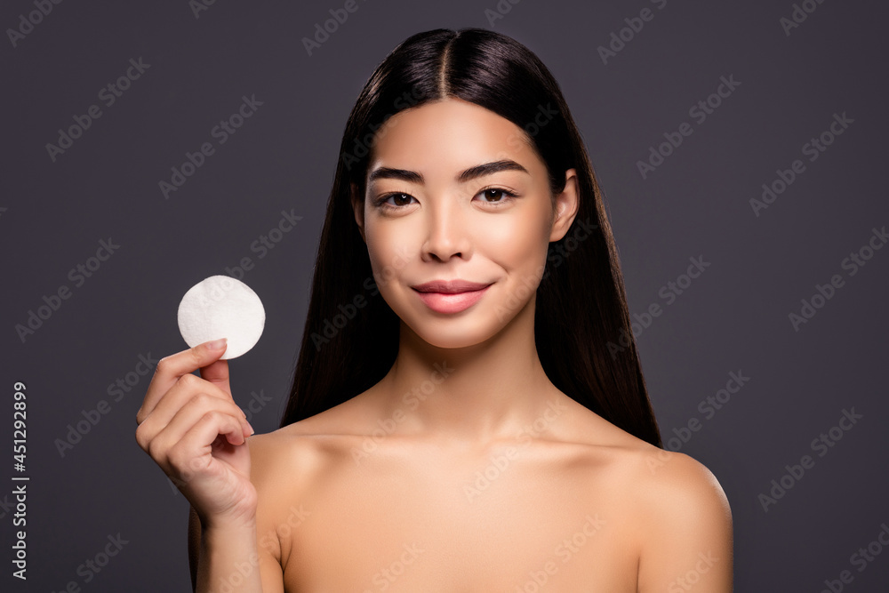Photo of charming positive model lady hold cotton disk demonstrate new best product isolated grey color background Photo of charming positive model lady hold cotton disk demonstrate new best product isolated grey color background