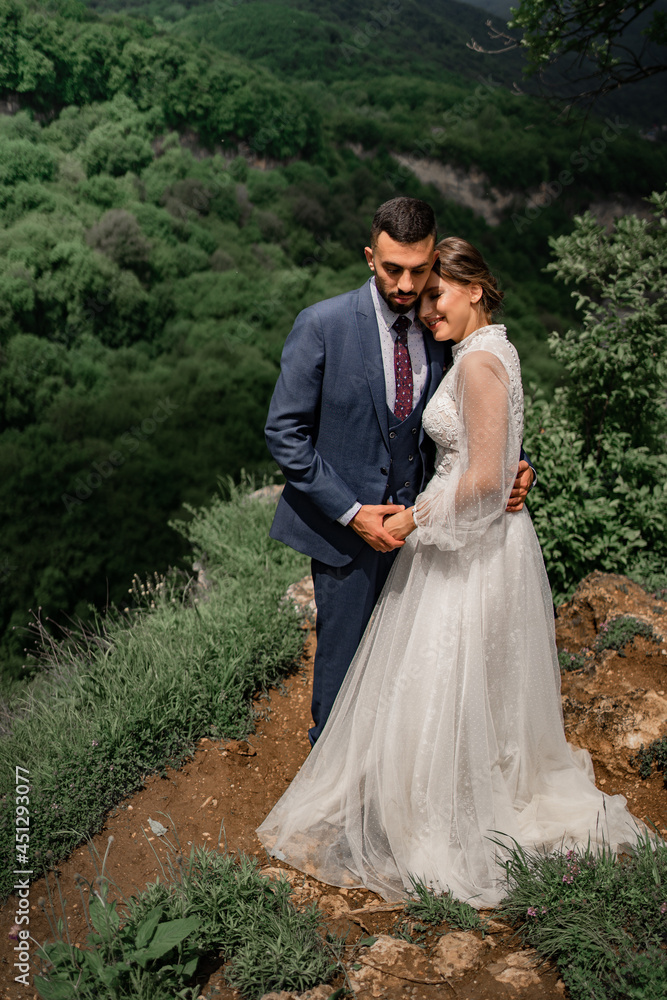 a beautiful hugging couple of newlyweds in a wedding ceremony in the mountains a beautiful hugging couple of newlyweds in a wedding ceremony in the mountains