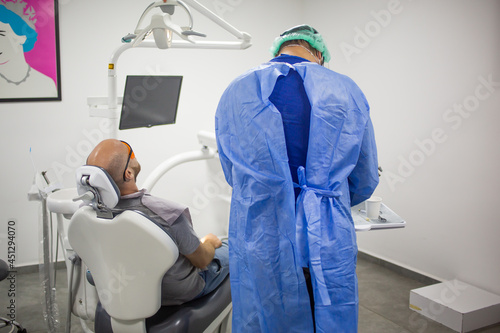 Caucasian male is waiting for a teeth check up in a dental chair in a dentist office