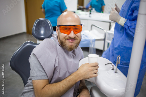 Caucasian male is rinsing his mouth during a wisdom tooth extraction surgery in a dental hospital