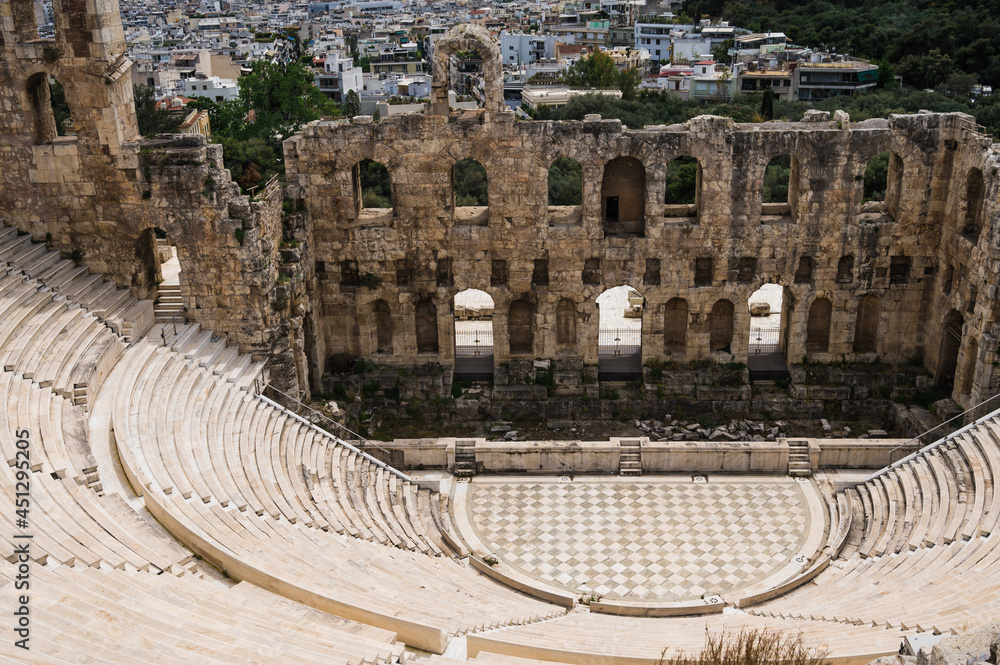 Remains of The Odeon of Herodes Atticus in Athens. Cityscape of Athens at cloudy day. Acropolis hill.