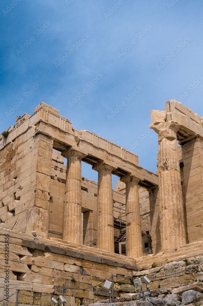 Remains of ancient temple on Acropolis hill in Athens, Greece. Marble columns. Antique ruins. Bottom view. Cloudy sky.