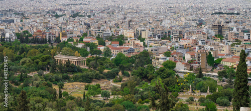 Cityscape of Athens at cloudy day. Urban architecture in Europe. View from Acropolis hill of The Temple of Hephaestus. Green trees. photo