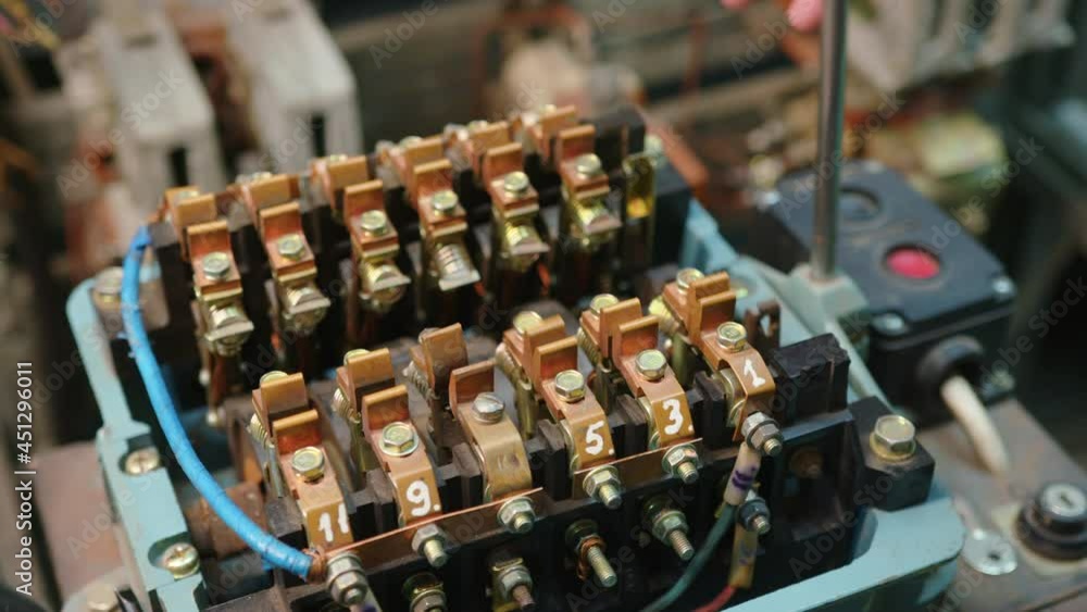 Closeup. Electricians hands testing current electric in control panel. Electrician engineer work tester measuring voltage and current of power electric line in electical cabinet control.