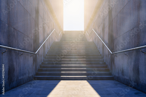 Stone stairs. Granite up staircase. Worm light in door at end of the stairway up. Granite stairs leading up towards light. Concept of hope and bright future.