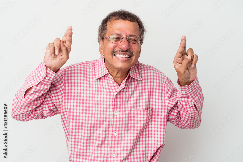 Middle aged indian man isolated on white background crossing fingers for having luck Middle aged indian man isolated on white background crossing fingers for having luck