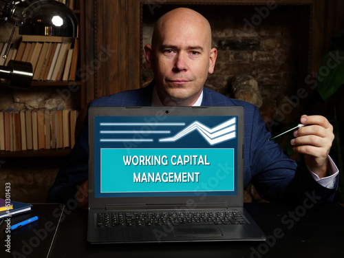  WORKING CAPITAL MANAGEMENT inscription on the screen. Close up Marketing expert hands holding black smart phone.