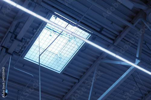 ceiling of industrial building with ventilation window with automatic opening and LED lamp in shopping center or warehouse