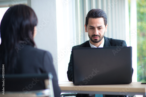 Business man look notebook serious with business woman foreground