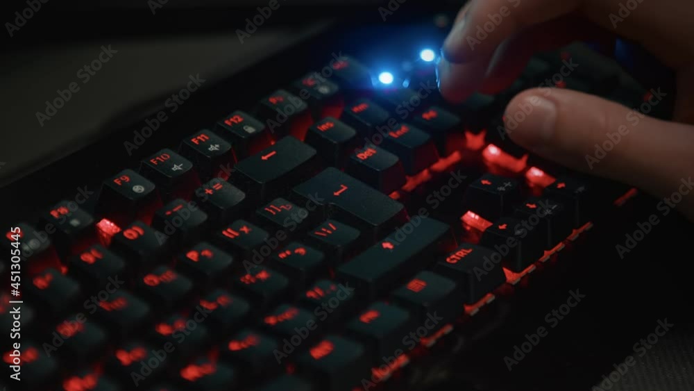 Pressing buttons on a backlit keyboard close-up