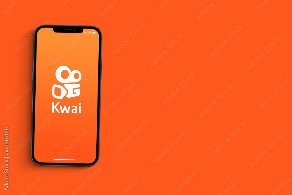 Kwai app on smartphone screen on orange background. Social media