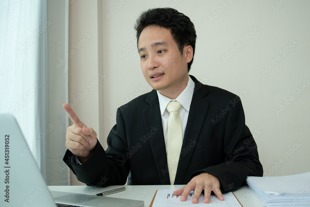 Asian young businessman making an online video conference while working at home. Asian young businessman making an online video conference while working at home.