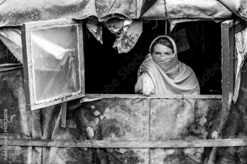 Young European girl in a nomad tent window. Black and white portait