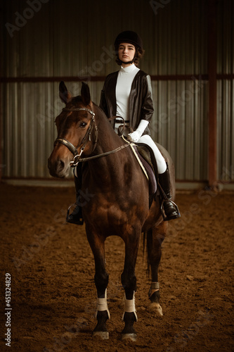 Unknown rider on a dressage horse. An abstract shot of a horse during the competition. Cute girl jockey sitting in the saddle on a horse shooting close-up. © Екатерина Переславце