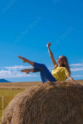a girl is sunbathing in the hay. village life: harvesting hay for the winter. animal feed.